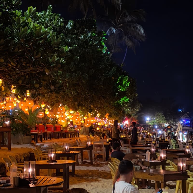 A candlelit restaurant on the sand at night